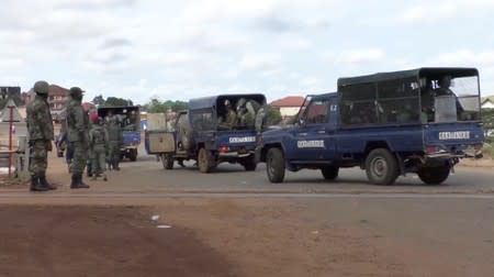 Riot police gather near a main road blocked by protesters in Sonfonia District in Conakry