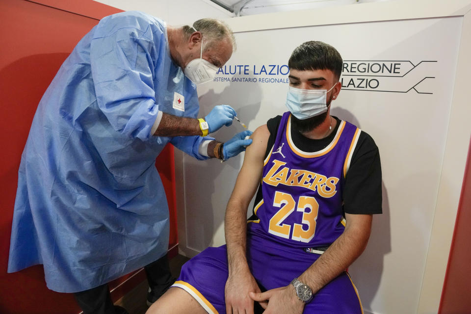 A student is administered his first dose of Pfizer/BioNTech Covid-19 vaccine, at a vaccination hub in a shopping mall in the outskirts of Rome, Tuesday, June 1, 2021. Eighteen-year-old students in Rome were administered their first dose of the Pfizer/BioNTech vaccine in Rome on Tuesday, in view of their upcoming final exams. The vaccination hub at the Porta di Roma Mall on the outskirts of Rome began vaccinating students ahead of their finals which begin in a few weeks. (AP Photo/Andrew Medichini)