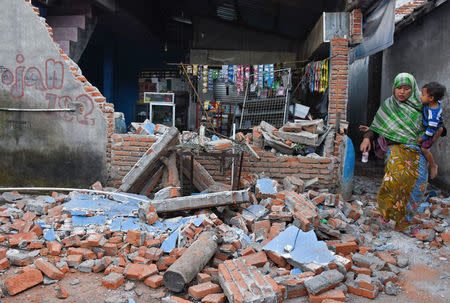 A woman walks past debris from a collapsed wall following a strong earthquake in Lendang Bajur Hamlet, Lombok island, indonesia August 6, 2018 in this photo taken by Antara Foto. Antara Foto/Ahmad Subaidi/ via REUTERS