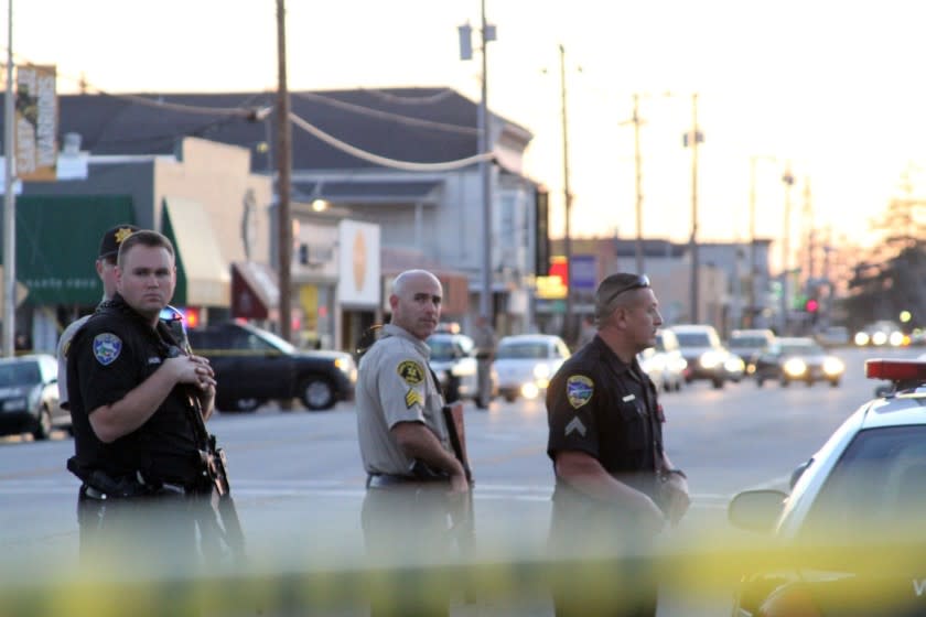 Police secure the scene. The loss of the two officers follows a recent series of violent incidents in the city and was especially devastating for the small Police Department, which has about 90 sworn officers.