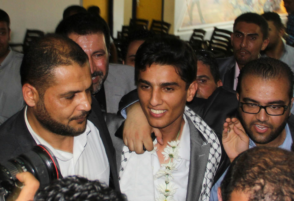 Arab Idol winner Palestinian Mohammed Assaf, center, arrives to the Rafah crossing point on the border between Egypt and southern Gaza Strip, Tuesday, June 25, 2013. Huge crowds of Gazans gave a gleeful welcome Tuesday to the first Palestinian winner of the Arab Idol talent contest, thronging the territory's border crossing with Egypt and the singer's home in hopes of embracing him, but internal politics surfaced quickly. Assaf’s victory in the popular contest Saturday sparked huge celebrations in the West Bank and Gaza, giving Palestinians a sense of pride. (AP Photo/Khaled Omar, Pool)