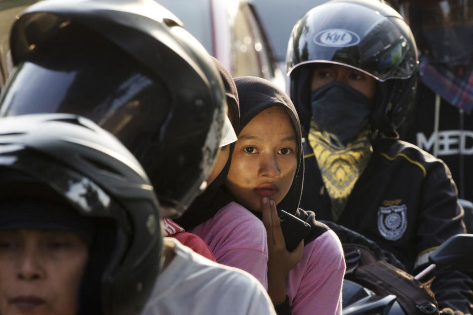 People ride motorcycles in Bekasi on the outskirts of Jakarta, Indonesia, Thursday, May 30, 2019. The mass exodus out of Jakarta and other major cities in the world's most populous Muslim country is underway as millions are heading home to their villages to celebrate Eid al-Fitr holiday that marks the end of the holy fasting month of Ramadan. (AP Photo/Achmad Ibrahim)