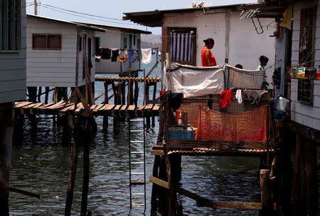 Residents walk along a wooden path that joins stilt houses in the village of Hanuabada, located in Port Moresby Harbour, Papua New Guinea, November 19, 2018. REUTERS/David Gray