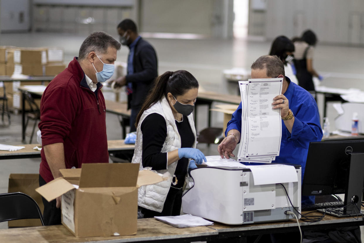 Workers scan ballots as the Fulton County presidential recount gets under way Wednesday morning, Nov. 25, 2020 at the Georgia World Congress Center in Atlanta.  (Ben Gray/AP)