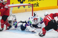 Norway's Jonas Arntzen, 2nd right, makes a save against Switzerland's Sven Senteler, right, during the preliminary round match between Switzerland and Norway at the Ice Hockey World Championships in Prague, Czech Republic, Friday, May 10, 2024. (AP Photo/Petr David Josek)