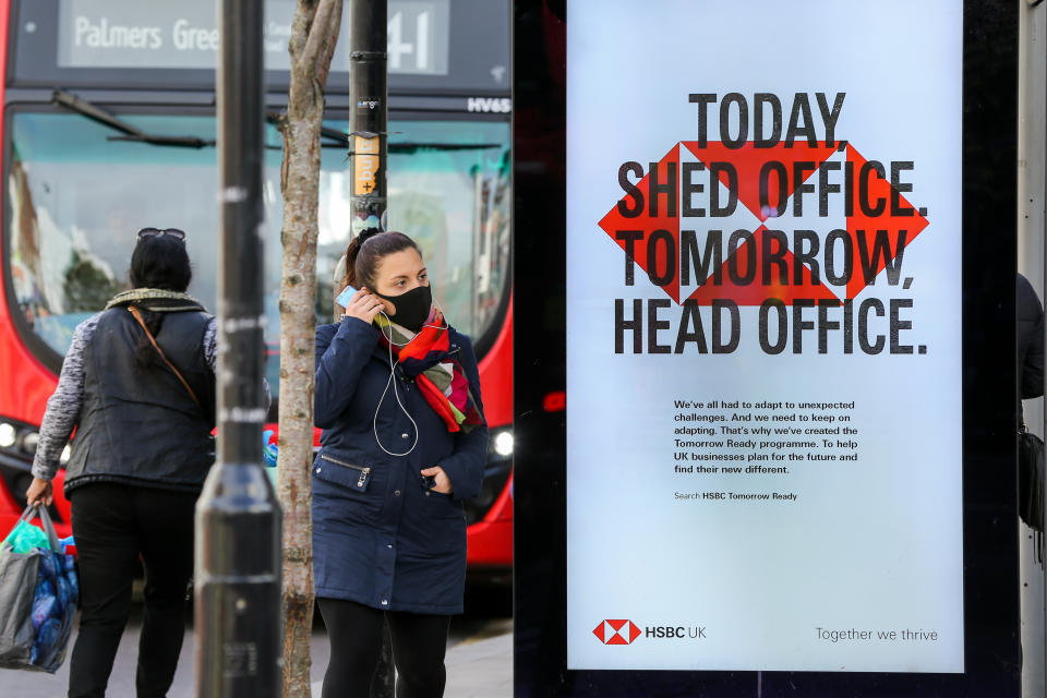 A woman wearing a face mask stands next to a HSBC bank's poster in London. (Photo by Dinendra Haria / SOPA Images/Sipa USA)