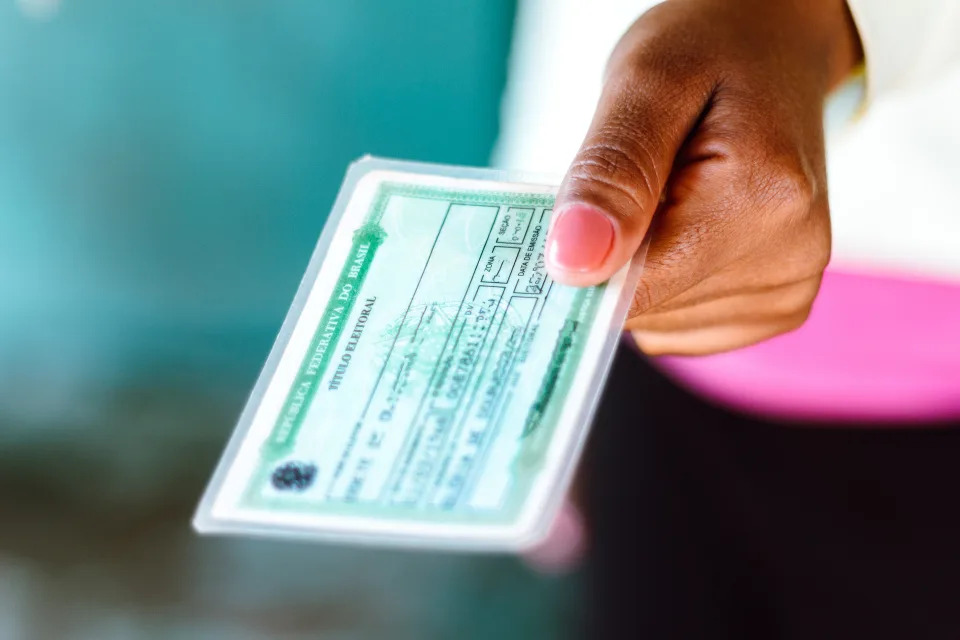 Mulher segura seu Título Eleitoral (Foto: Getty Editorial)