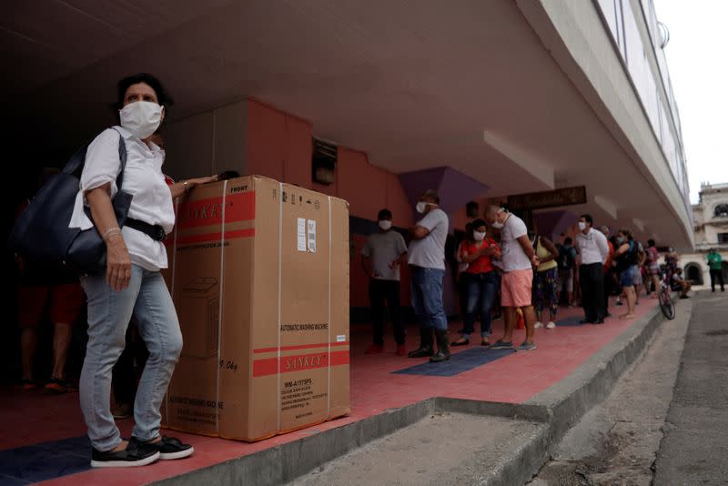 Gente hace fila para retirar productos, algunos comprados en línea, en medio de las preocupaciones por la propagación del COVID-19, en el centro de La Habana