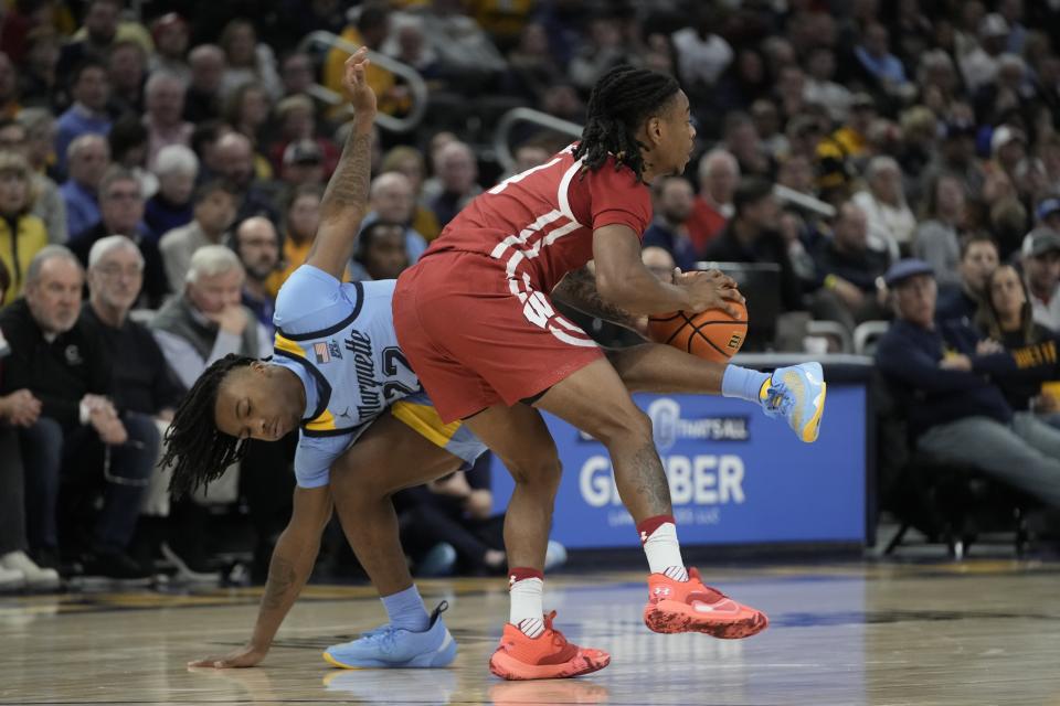 Marquette's Sean Jones fouls Wisconsin's Kamari McGee during the second half of an NCAA college basketball game Saturday, Dec. 3, 2022, in Milwaukee. Wisconsin won 80-77 in overtime. (AP Photo/Morry Gash)