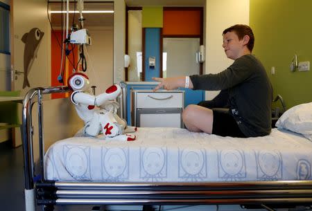 Belgian Ian Frejean, 11, plays with "Zora" the robot, a humanoid robot designed to entertain patients and to support care providers, at AZ Damiaan hospital in Ostend, Belgium June 16, 2016. REUTERS/Francois Lenoir