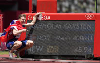 El noruego Karsten Warholm celebra frente al tablero que muestra su récord mundial fijado en la final de los 400 metros con vallas de los Juegos Olímpicos de Tokio, el martes 3 de agosto de 2021. (AP Foto/Martin Meissner)