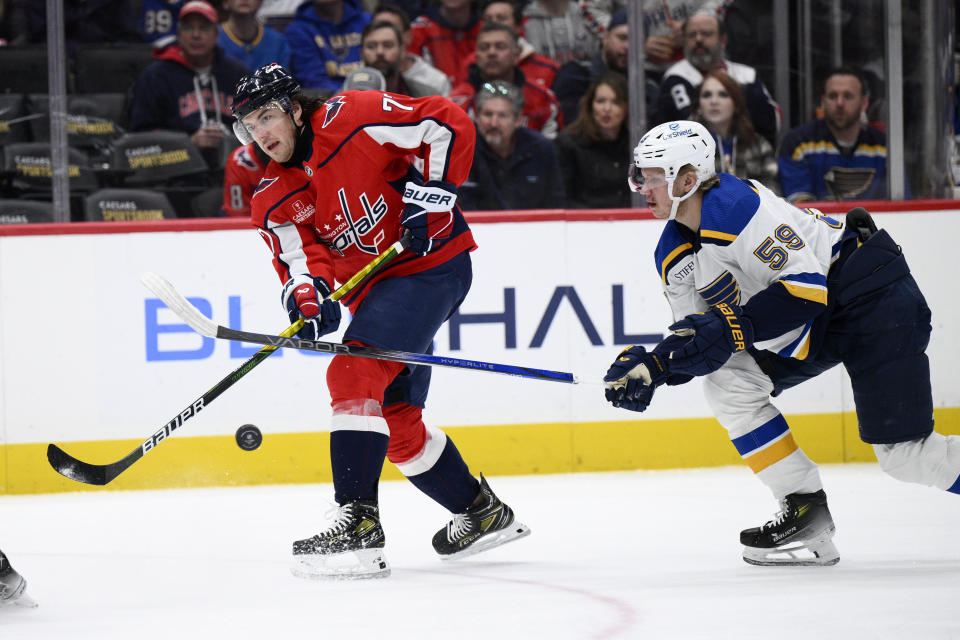 Washington Capitals right wing T.J. Oshie (77) passes the puck away from St. Louis Blues Nikita Alexandrov (59) during the first period of an NHL hockey game Thursday, Jan. 18, 2024, in Washington. (AP Photo/Nick Wass)