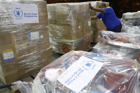 A worker arranges World Food Programme relief goods near Subang airport in Kuala Lumpur to be sent to victims of super typhoon Haiyan in the Philippines