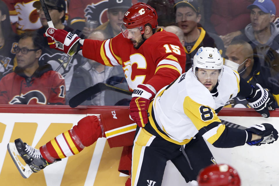 Pittsburgh Penguins' Brian Dumoulin, right, hits Calgary Flames' Brad Richardson during the first period of an NHL hockey game, Monday, Nov. 29, 2021 in Calgary, Alberta. (Larry MacDougal/The Canadian Press via AP)