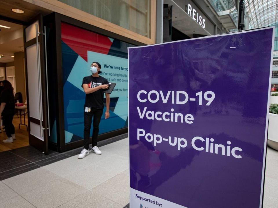 Health-care workers with Unity Health Toronto administer the Pfizer-BioNTech COVID-19 vaccine at a one-day pop-up clinic in the Eaton Centre mall in Toronto, on July 27, 2021.  (Evan Mitsui/CBC - image credit)