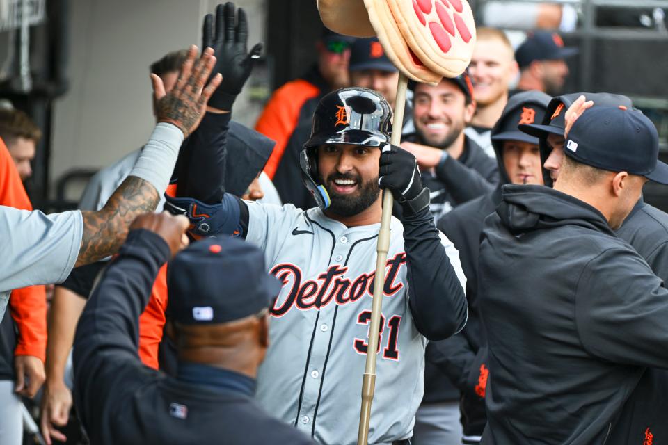 Detroit Tigers outfielder Riley Greene is congratulated by teammates following a home run during the seventh inning against the Chicago White Sox at Guaranteed Rate Field on March 30, 2024 in Chicago. He is holding a spear with three pizzas on it, a new celebration.