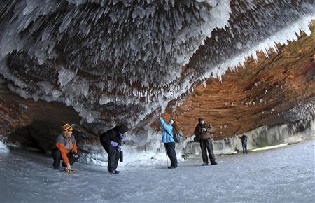 Sightseers crouch to avoid icicles in a sea cave on frozen Lake Superior, the world's largest freshwater lake, at the Apostle Islands National Lakeshore near Cornucopia, Wisconsin February 14, 2014. REUTERS/Eric Miller