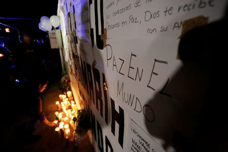 People light candles outside the Colegio Americano del Noreste after a teenage student shot several students and a teacher at the private school before killing himself, in Monterrey, Mexico, January 18, 2017. The sign on the wall reads "Peace in the world." REUTERS/Daniel Becerrilril