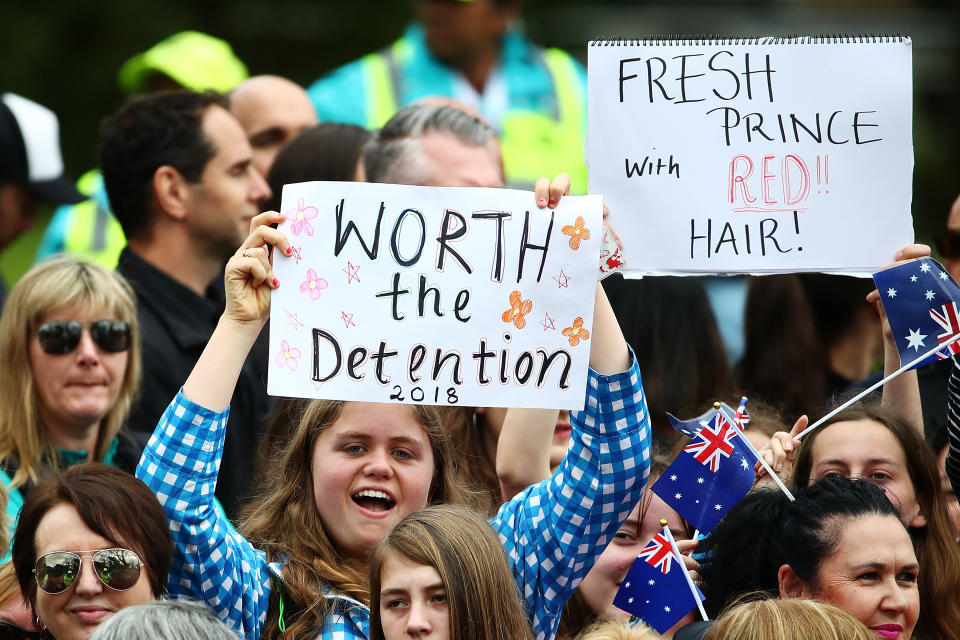 A young royal fan holds a sign while waiting for Harry and Meghan. Photo: Getty