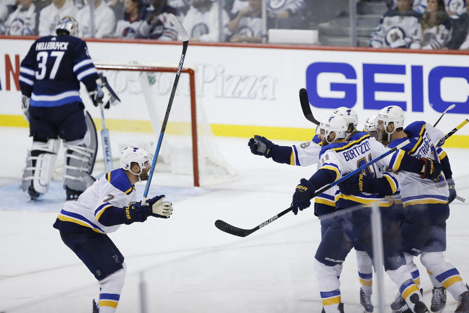 St. Louis Blues celebrate Tyler Bozak's goal against the Winnipeg Jets during the third period of Game 1 of an NHL hockey first-round playoff series Wednesday, April 10, 2019, in Winnipeg, Manitoba. Bozak is second from right, eyes and helmet visible. (John Woods/The Canadian Press via AP)