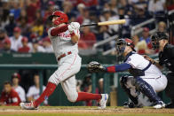 Philadelphia Phillies' Rhys Hoskins hits a two-run home run in front of Washington Nationals catcher Riley Adams and home plate umpire Mike Muchlinski in the fifth inning of a baseball game, Wednesday, Aug. 4, 2021, in Washington. (AP Photo/Patrick Semansky)