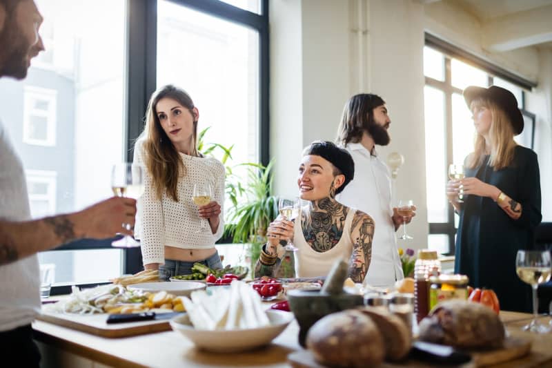 A group of friends during a dinner party having fun together, talking and drinking wine