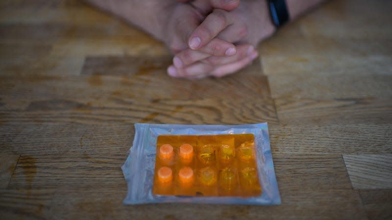 A pack of ketamine tablets is on a table in front of a patient's hands.