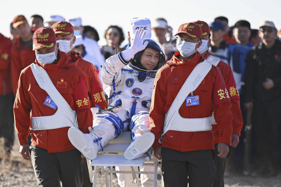 In this photo released by Xinhua News Agency, Chinese astronaut Jiang Xinlin waves as he is carried out of the re-entry capsule of the Shenzhou-17 manned space mission after it landed successfully at the Dongfeng landing site in northern China's Inner Mongolia Autonomous Region, Tuesday, April 30, 2024. China's Shenzhou-17 spacecraft returned to Earth Tuesday, carrying three astronauts who have completed a six-month mission aboard the country's orbiting space station. (Lian Zhen/Xinhua via AP)