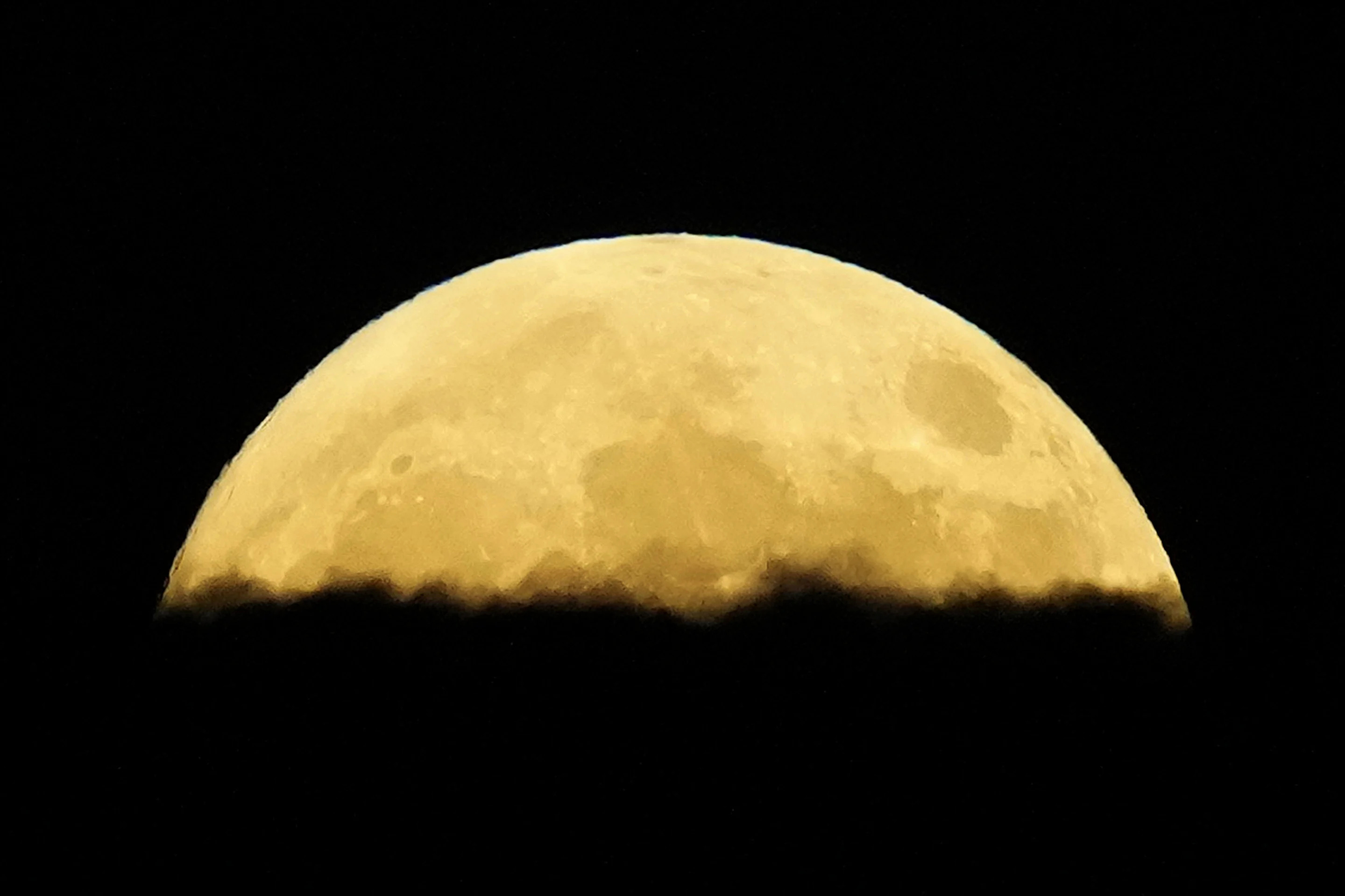 A supermoon rises behind clouds over Larnaca international airport in the eastern Mediterranean island of Cyprus on Tuesday.