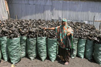 In this photo of Tuesday Oct. 30, 2012, A Somali charcoal trader scales charcoal at his charcoal shop in Mogadishu, Somali. Thousands of sacks of dark charcoal sit atop one another in Somalia's southern port city of Kismayo, an industry once worth some $25 million dollar a year to the al-Qaida-linked insurgents who controlled the region. The good news sitting in the idle pile of sacks is that al-Shabab militants can no longer fund their insurgency through the illegal export of the charcoal. Kenyan troops late last month invaded Kismayo and forced out the insurgents, putting a halt to the export of charcoal, a trade the U.N. banned earlier this year in an effort to cut militant profits. The loss of the charcoal trade "will cut a major source of revenue and thus will have a detrimental effect on their operational capacity to carry out large scale attacks," Mohamed Sheikh Abdi, a Somali political analyst, said of al-Shabab. But the flip side to the charcoal problem is that residents who made their living from the trade no longer are making money, a potentially tricky issue for the Kenyan troops who now control the region. (AP Photo/Farah Abdi Warsameh)