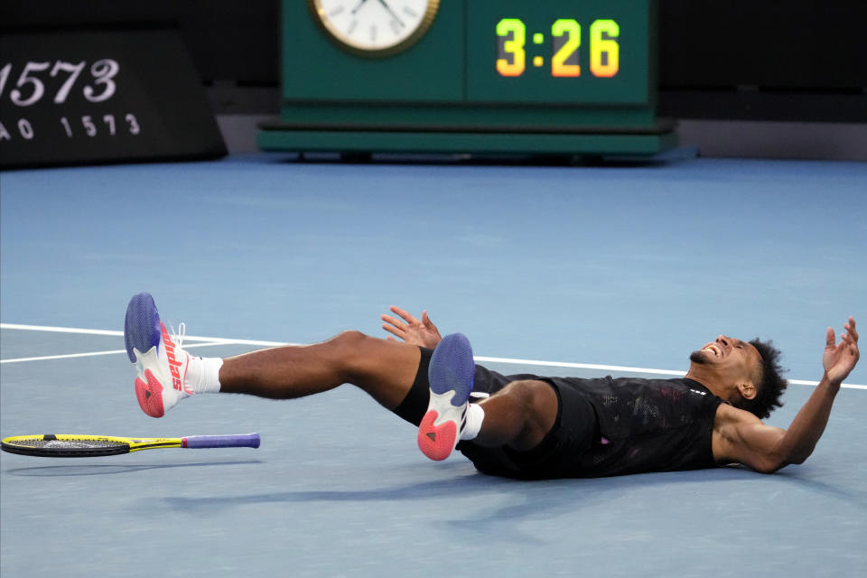 Michael Mmoh of the U.S. falls to the court as he celebrates after defeating Alexander Zverev of Germany in their second round match at the Australian Open tennis championship in Melbourne, Australia, Thursday, Jan. 19, 2023. (AP Photo/Ng Han Guan)