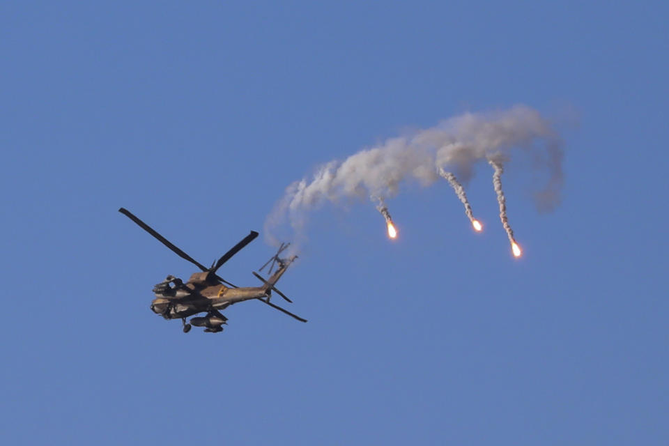 An Israeli attack helicopter launches flares as he flies over the Israeli Gaza border, southern Israel, Thursday, May 13, 2021. (AP Photo/Ariel Schalit)