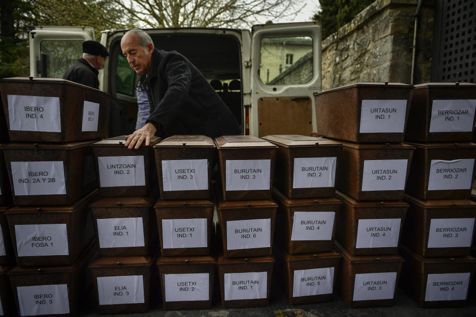 A man moves some of 46 unidentified people killed during the Spanish Civil War, in Pamplona, northern Spain, Monday, April 1, 2019. Marking eight decades since the end of the Spanish Civil War, the remains of 46 unidentified victims of the conflict have been reburied in the northern city of Pamplona. More than half a million people died in the 1936-1939 war between rebel nationalist forces led by Gen. Francisco Franco and defenders of the short-lived Spanish republic. (AP Photo/Alvaro Barrientos)