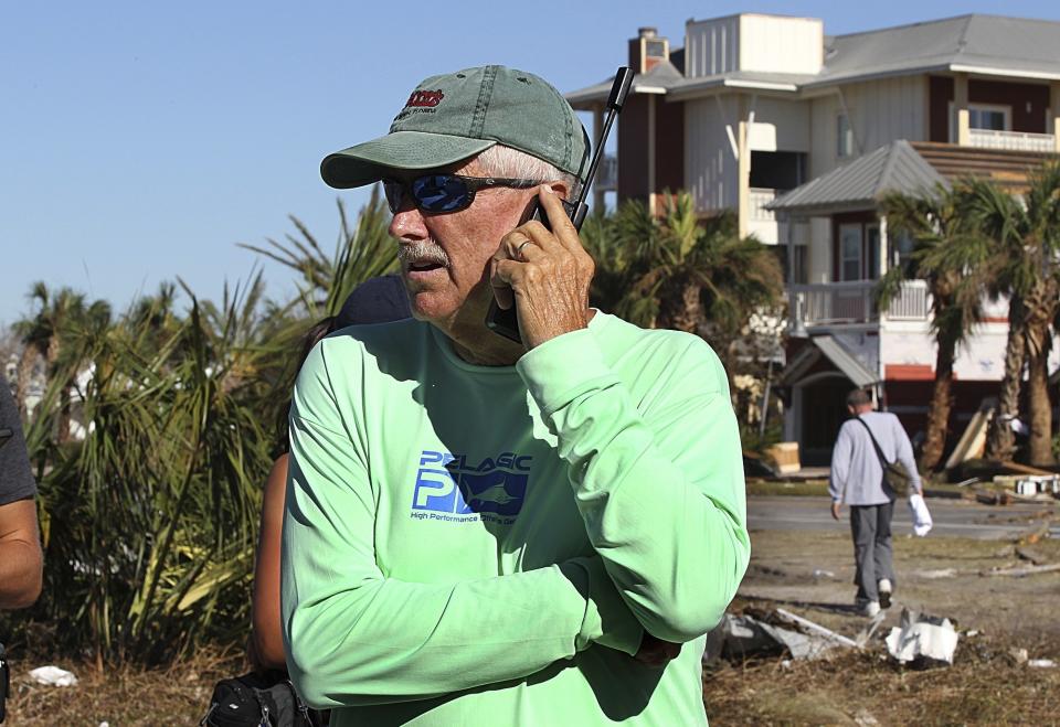 FILE - Mexico Beach, Fla., Mayor Al Cathey, calls on a satellite phone in Mexico Beach, on Friday, Oct. 12, 2018, two days after a Category 4 Hurricane Michael devastated the small coastal town just outside Panama City, Fla. The federal agency in charge of emergency management is making changes to its program that helps those who survive wildfires, hurricanes and other natural disasters. Federal Emergency Management Agency head Deanne Criswell says the changes are designed to simplify and speed up the process for disaster survivors to get help. (Pedro Portal/Miami Herald via AP, File)