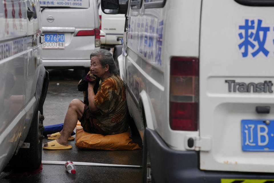 An elderly woman wipes her face sitting next to a rescue vehicle after evacuated from flooding Zhuozhou in northern China's Hebei province, south of Beijing, Wednesday, Aug. 2, 2023. China's capital has recorded its heaviest rainfall in at least 140 years over the past few days. Among the hardest hit areas is Zhuozhou, a small city that borders Beijing's southwest. (AP Photo/Andy Wong)