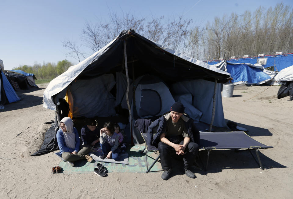 An Afghan family rest in the makeshift refugee camp near the border crossing into Hungary, near Horgos, in Serbia, Tuesday, March 28, 2017. Hungary's new legislation allowing for the placement of all asylum-seekers in border container camps took effect Tuesday, with the European Union's commissioner for migration saying that it needs to comply with the bloc's rules. (AP Photo/Darko Vojinovic)