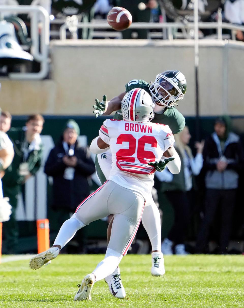 Oct 8, 2022; East Lansing, Michigan, USA; Ohio State Buckeyes cornerback Cameron Brown (26) tries to defend the Michigan State Spartans wide receiver Keon Coleman (0) from making a catch in the first quarter of the NCAA Division I football game between the Ohio State Buckeyes and Michigan State Spartans at Spartan Stadium.  Ohio State Buckeyes cornerback Cameron Brown (26) was called for pass interference on the play.