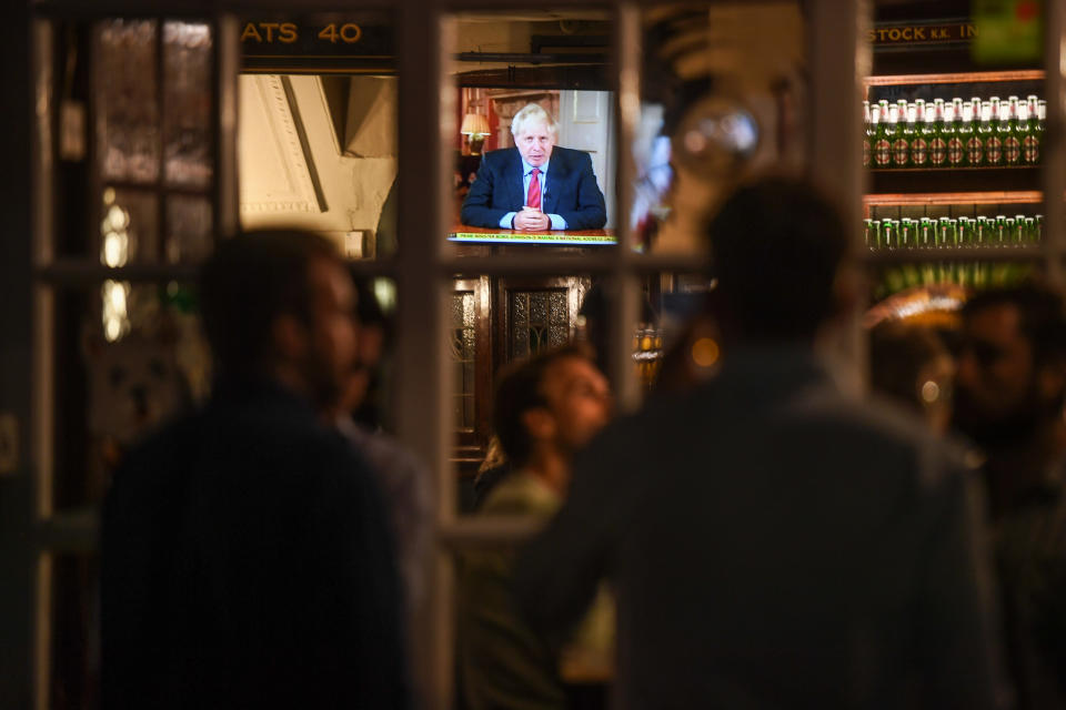 LONDON, ENGLAND - SEPTEMBER 22: People watch British Prime Minister Boris Johnson making a televised address to the nation inside the Westminster Arms pub on September 22, 2020 in London, England. The UK Prime Minister announced extra measures to combat the spread of Covid-19 cases in the House of Commons today. From Thursday face masks will become compulsory for bar staff, shop workers, waitering staff and taxi drivers. Office workers should work from home where possible and all pubs, bars and restaurants must offer table service only and close by 10pm.  (Photo by Peter Summers/Getty Images)