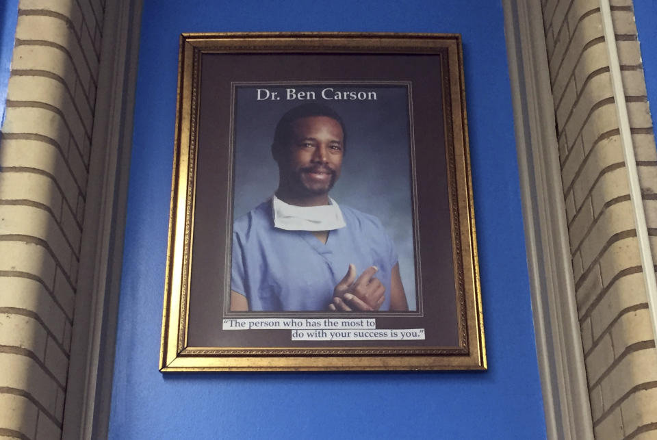 In this May 3, 2018, photo, a portrait of Ben Carson hangs in the Ben Carson Reading Room inside of the Archbishop Borders School in Baltimore. The portrait used to hang in the school's hallway, but Principal Alicia Freeman moved it out of public view during Carson's presidential campaign. Carson’s story of growing up in a single-parent household and climbing out of poverty to become a world-renowned surgeon was once ubiquitous in Baltimore, where Carson made his name. But his role in the Trump Administration has added a complicated epilogue, leaving many who admired him feeling betrayed, unable to separate him from the politics of a president widely rejected by African Americans here. (AP Photo/Juliet Linderman)