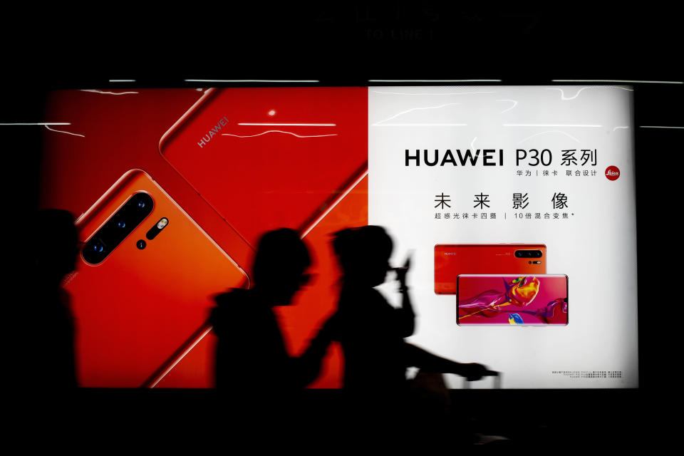 Commuters walk by the new Huawei P30 smartphone advertisement on display inside a subway station in Beijing Monday, May 13, 2019. China's intensified tariff war with the Trump administration is threatening Beijing's ambition to transform itself into the dominant player in global technology. (AP Photo/Andy Wong)