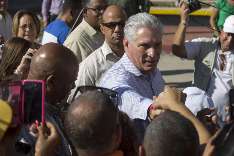 Cuba's President Miguel Diaz-Canel greets residents as he arrives in Caimanera, Cuba, Thursday, Nov. 14, 2019. Díaz-Canel is making his first trip to the town of Caimanera, the closest point in Cuba to the U.S. naval base at Guantanamo Bay. He arrived on Thursday morning. ( AP Photo/Ismael Francisco)