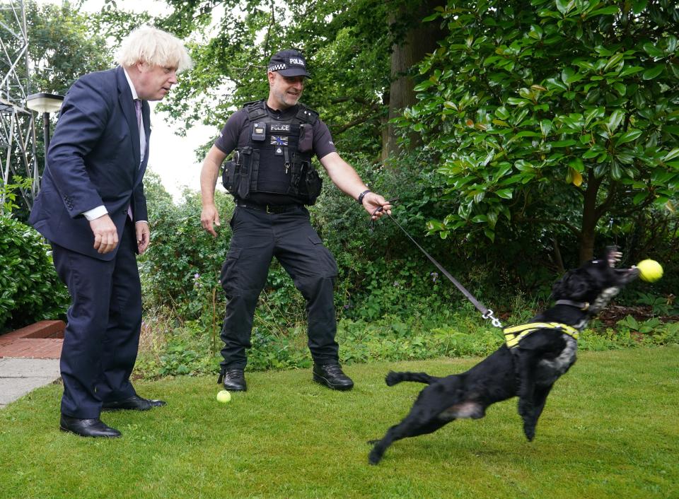 Prime Minister Boris Johnson speaks to Sergeant Dog Handler Mike Barnes as he throws a ball for six-year-old cocker spaniel Rebel (Yui Mok/PA) (PA Wire)