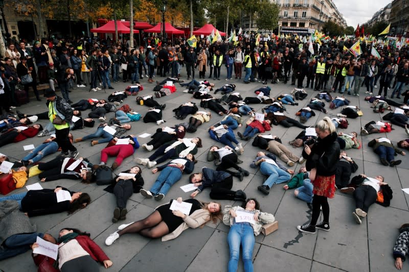 People stage a "die-in" at Place de la Republique during a demonstration against femicide and violence against women in Paris