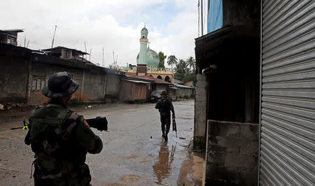 Government soldiers patrol a deserted street in Marawi City, southern Philippines May 27, 2017. REUTERS/Erik De Castro