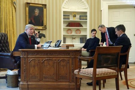 U.S. President Donald Trump, joined by senior advisor Jared Kushner (3rd R), Communications Director Sean Spicer (2nd R) and National Security Advisor Michael Flynn (R), speaks by phone with Saudi Arabia's King Salman in the Oval Office at the White House in Washington, U.S. January 29, 2017. REUTERS/Jonathan Ernst