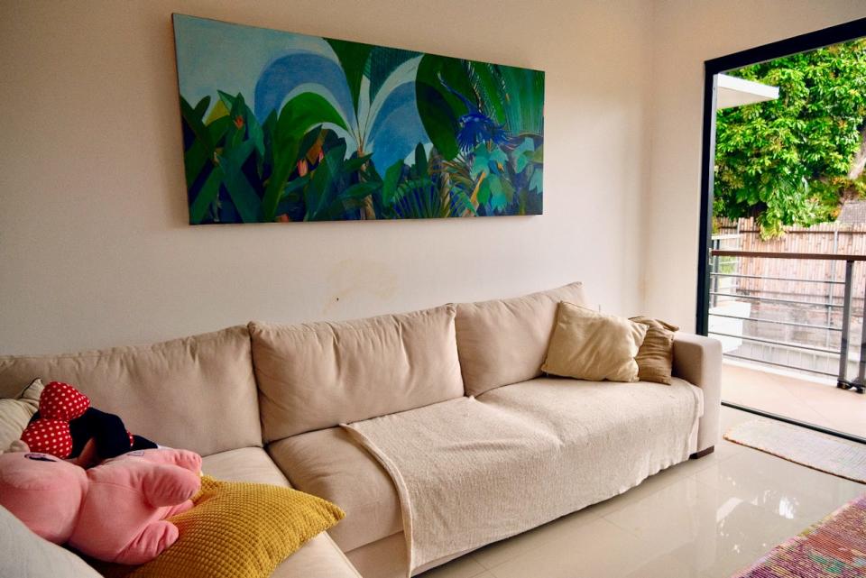 A white sofa sits in the living room on the upper floor of their villa.