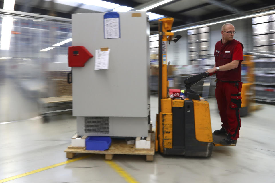 File -- In this Tuesday, Nov. 24, 2020 file photo an employee of Binder, the world's largest manufacturer of serial-production environmental simulation chambers for scientific or industrial laboratories, transports an ultra low temperature freezer in Tuttlingen, Germany. Germany prepares for the vaccination of the German population during the upcoming month. (AP Photo/Matthias Schrader, file)