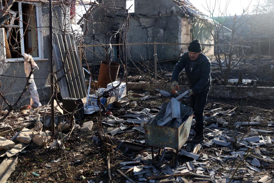 A local resident cleans debris in the courtyard of his house destroyed as a result of a drone attack (AFP via Getty Images)