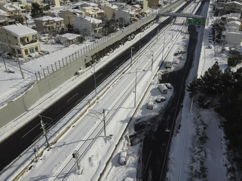 Abandoned vehicles are seen in an motorway way after a snowstorm, in Athens, on Tuesday, Jan. 25, 2022. Army and fire service teams were deployed late Monday to extract hundreds of motorists trapped for hours in snowed-in cars. A snowstorm of rare severity disrupted road and air traffic Monday in the Greek capital of Athens and neighboring Turkey's largest city of Istanbul, while most of Greece, including — unusually — several Aegean islands, and much of Turkey were blanketed by snow. (AP Photo/Michael Varaklas)