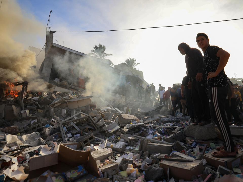 Palestinians stand above debris after Israeli bombardment in Khan Yunis in the southern Gaza Strip (AFP via Getty Images)